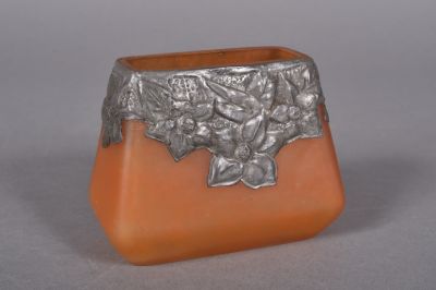 a silver and orange vase with a flower design on it
