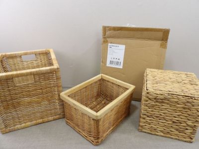 trois paniers de rangement en osier avec des poignées, posés à même le sol
