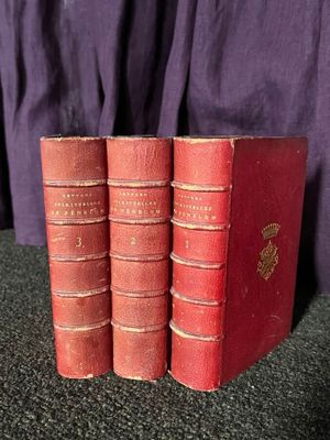 trois livres rouges superposés sur une table