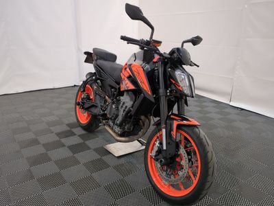 a black and orange motorcycle parked on a black and white checkered floor