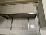 a picture of a kitchen with a metal shelf above the sink