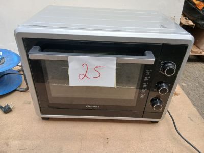 un four grille-pain posé sur une table, avec un mot collé dessus
