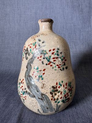 un petit vase orné d'un oiseau sur fond bleu