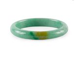 a close up of a green jade bangle on a white background