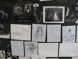 a black and white photo of a bunch of drawings on a wall