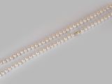 a close up of a pearl necklace on a white surface