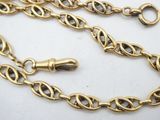 a close up of a gold chain on a white surface