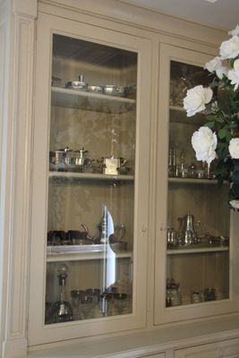 un vase contenant des fleurs blanches, exposé dans une vitrine en verre
