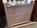 une commode sur laquelle sont posées des tasses et des soucoupes