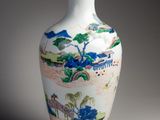 un vase blanc avec un tableau posé sur une table