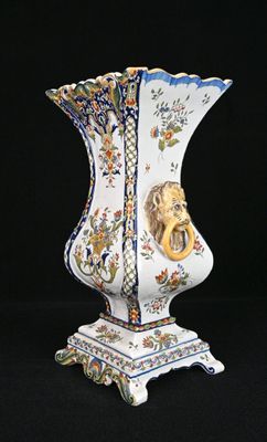 un vase orné d'une tête de lion sur fond noir