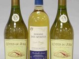 trois bouteilles de vin blanc posées les unes à côté des autres sur une table