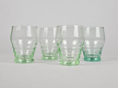trois verres verts posés sur une table blanche