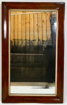 le reflet d'un homme dans un miroir accroché au mur