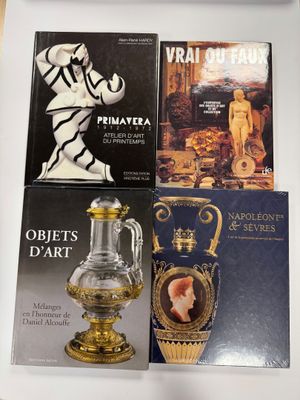 quatre livres posés sur une table avec un vase et un vase