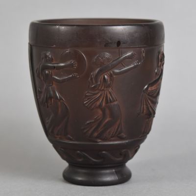 un vase marron orné d'un motif, posé sur une table