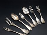 six forks and spoons are arranged in a row on a black surface