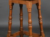 an old wooden stool with turned legs and a wooden seat