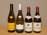 quatre bouteilles de vin sont alignées sur une table