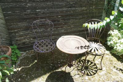 une petite table et deux chaises dans le jardin