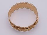 a close up of a gold bracelet on a white surface