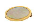 an oval mother of pearl locke with a gold clasp on a white background