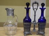 trois vases en verre bleu et un vase en argent posés sur une table