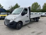un camion argenté garé sur un parking, avec d'autres camions en arrière-plan