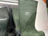green rubber boots are on a shelf in a store