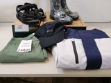 Plusieurs paires de bottes de pluie, un sac et une paire de bottes de pluie sont posés sur une table