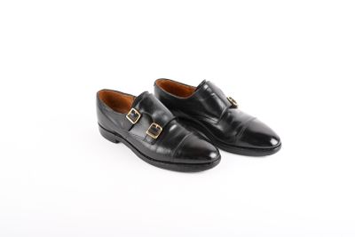 a pair of black leather shoes with a gold buckle