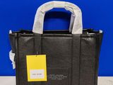 a close up of a black handbag with a yellow tag on it