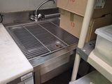 a kitchen with a sink and a lot of clutter on the counter