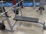 a gym with a bench, weights, and other equipment on the floor