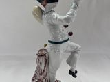 porcelain figurine of a man holding a baseball bat on a tree stump