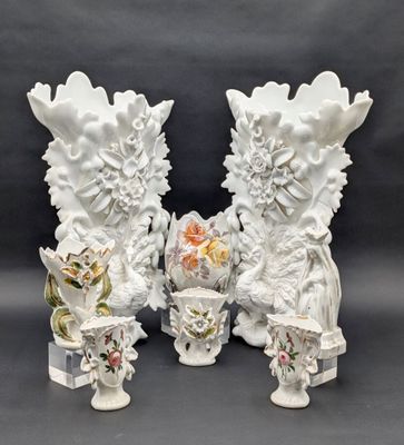 deux vases blancs décorés de fleurs, posés sur une table