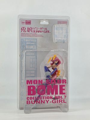 a small plastic figure of a woman in a pink outfit