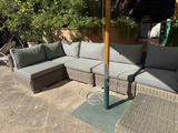 an image of a patio with a couch and umbrella