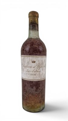 an old bottle of wine sitting on top of a white surface