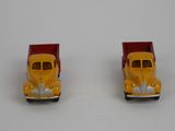 two toy trucks that are sitting side by side on a white surface