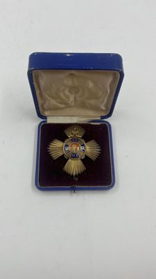 une image représentant une petite boîte bleue contenant une médaille d'or