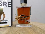 a bottle of perfume sitting on a table next to a box