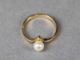 a close up of a gold ring with a pearl on it