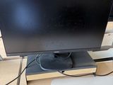 un écran d'ordinateur posé sur un bureau en bois