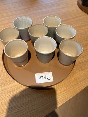 six tasses de café posées sur une assiette, sur une table