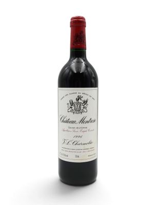 the bottle of wine is sitting on a white surface
