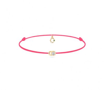 un bracelet en fil rouge orné d'une breloque en forme de cœur doré