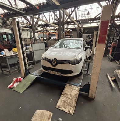 une voiture posée sur un pont élévateur dans un garage