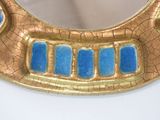 a gold and blue mirror on a white table