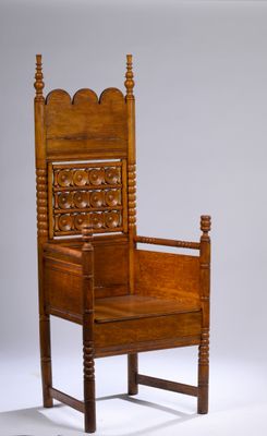 une chaise en bois dont l'assise est sculptée, sur fond blanc